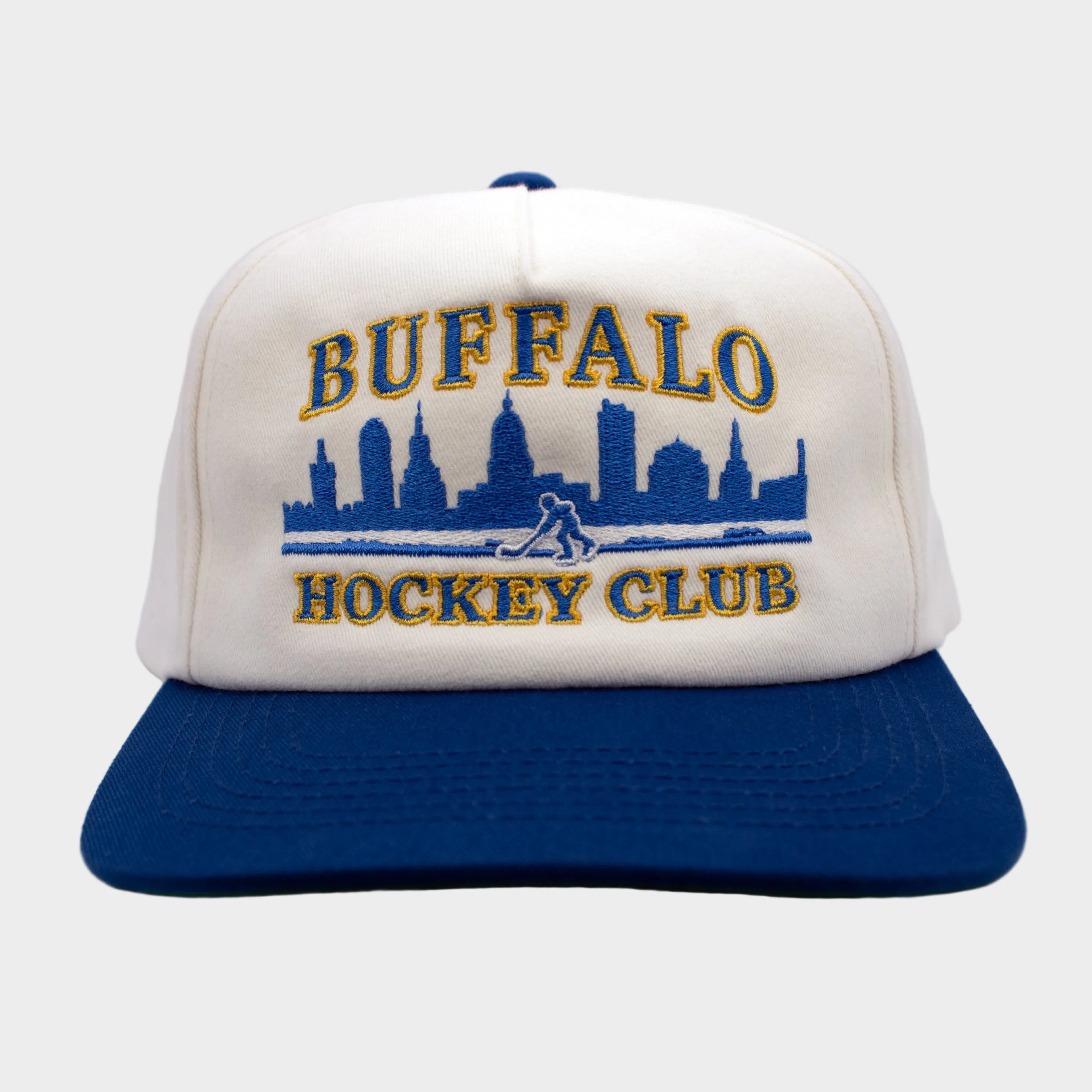 White and blue cap with 'Buffalo Hockey Club' text and skyline design on a light gray background