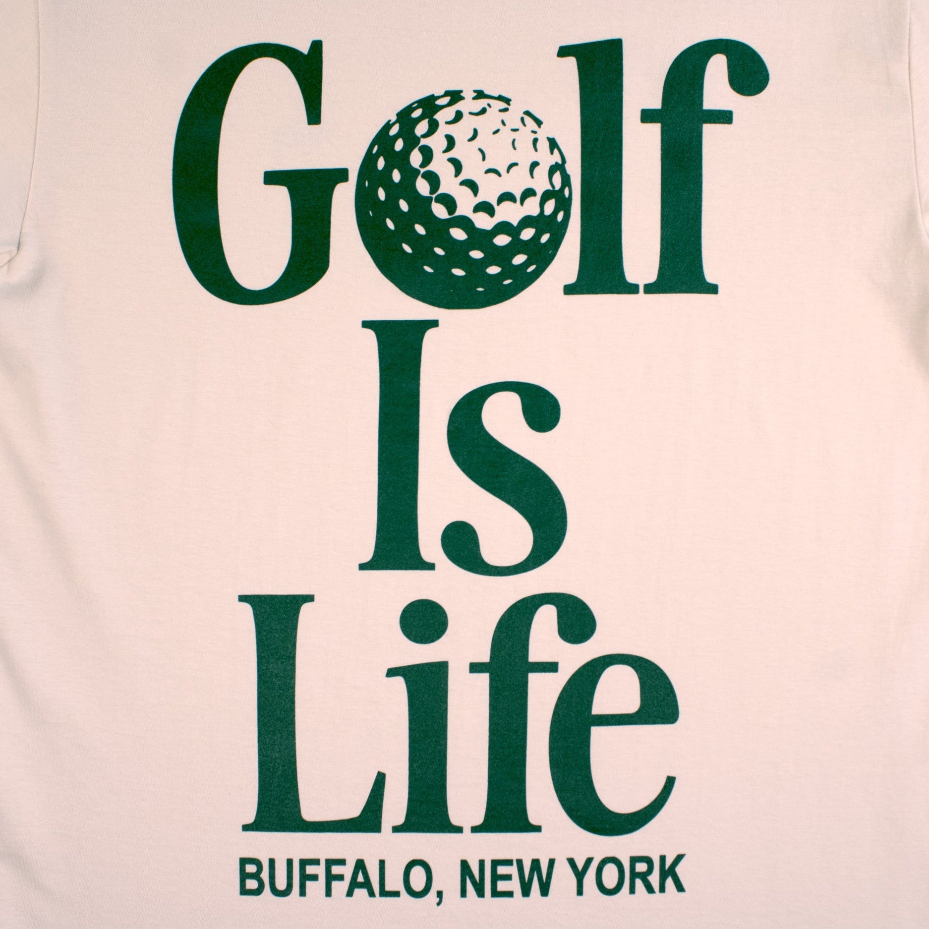 Beige t-shirt with 'Golf Is Life' text and a golf ball graphic on a light gray background
